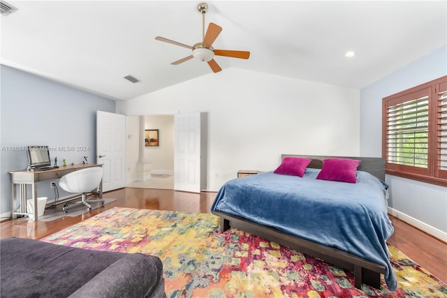 bedroom with vaulted ceiling, hardwood / wood-style floors, ceiling fan, and ensuite bath