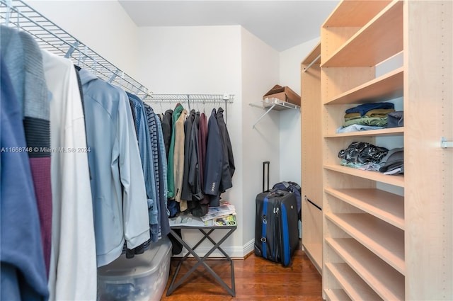 walk in closet with dark hardwood / wood-style flooring