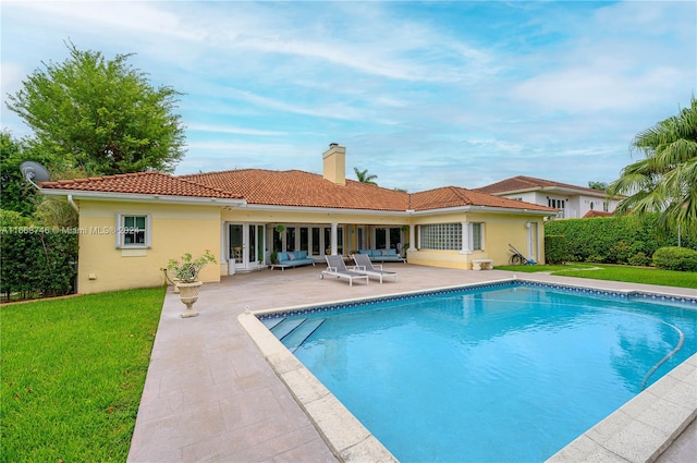 view of pool with a lawn, french doors, and a patio area