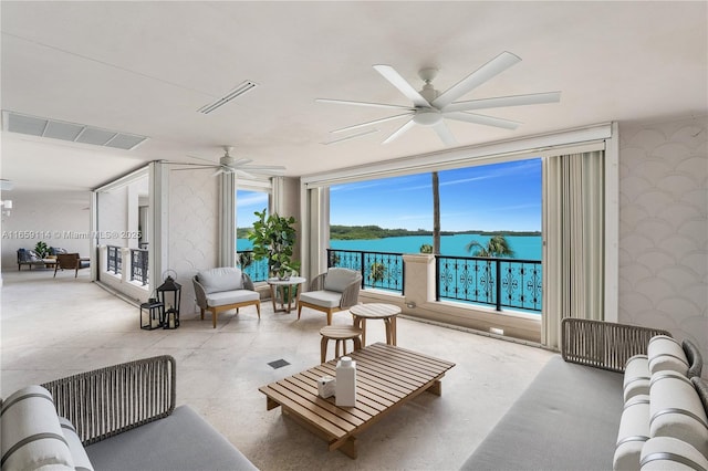 living room with a water view and ceiling fan