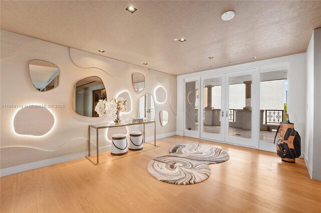 sitting room featuring hardwood / wood-style flooring, a textured ceiling, and french doors