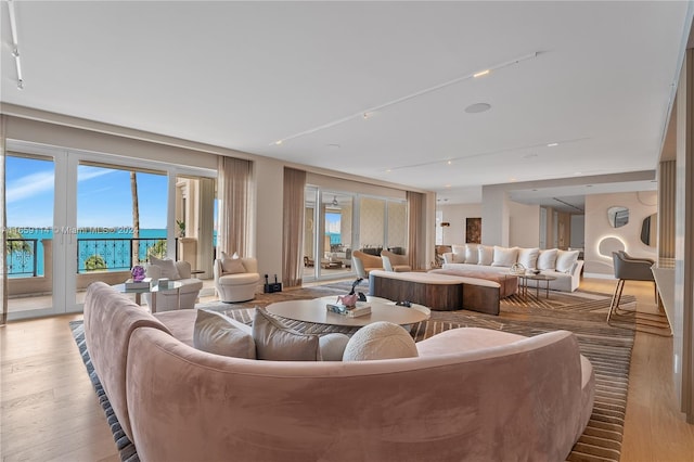 living room with a water view and light hardwood / wood-style flooring