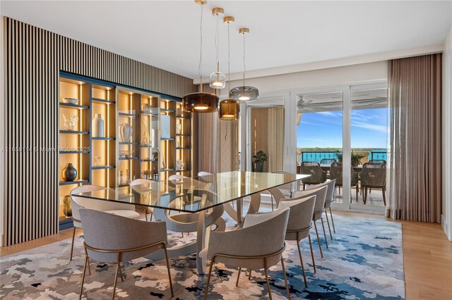 dining room featuring light hardwood / wood-style floors, a water view, and ceiling fan