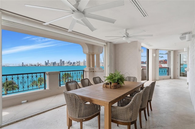 dining room with a water view and ceiling fan