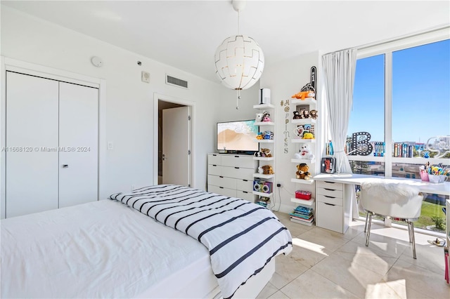 bedroom with a closet and light tile patterned floors