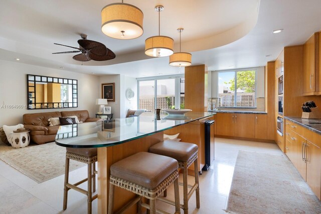 kitchen featuring pendant lighting, beverage cooler, a kitchen breakfast bar, backsplash, and appliances with stainless steel finishes