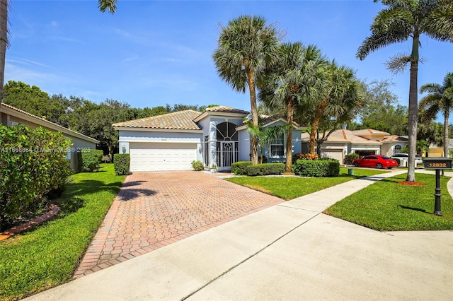 mediterranean / spanish-style house with a garage and a front lawn