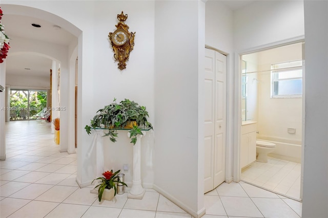 corridor featuring light tile patterned flooring and a wealth of natural light