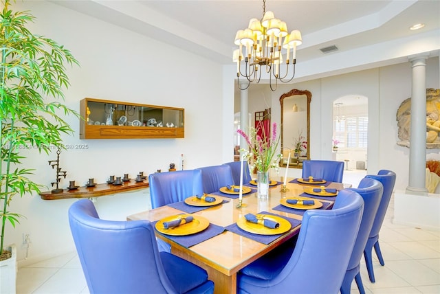 dining room with decorative columns, a raised ceiling, a chandelier, and light tile patterned flooring