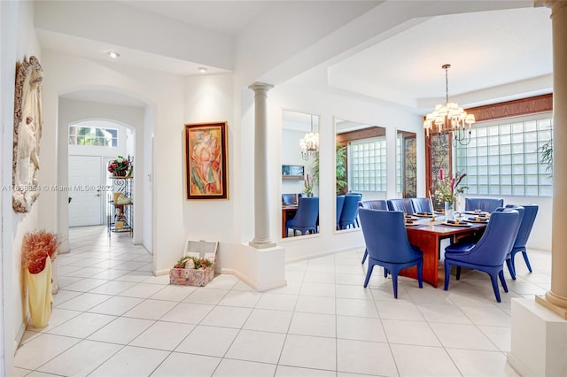 dining space featuring a notable chandelier, light tile patterned flooring, and ornate columns