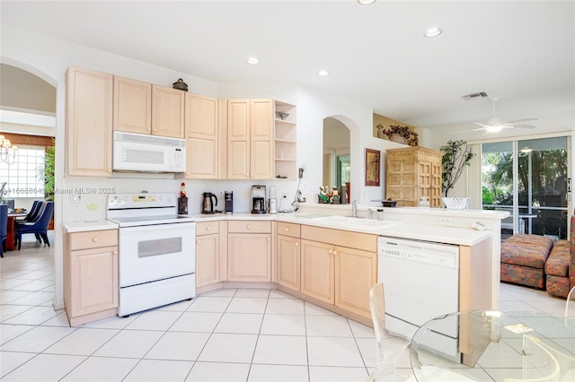 kitchen featuring light tile patterned flooring, light brown cabinetry, sink, kitchen peninsula, and white appliances