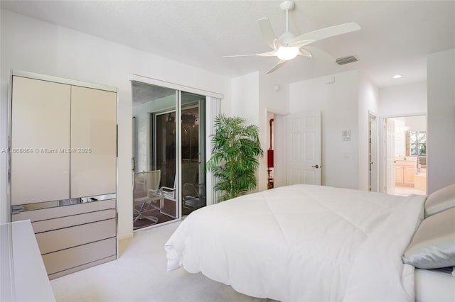 carpeted bedroom featuring connected bathroom, a textured ceiling, and ceiling fan