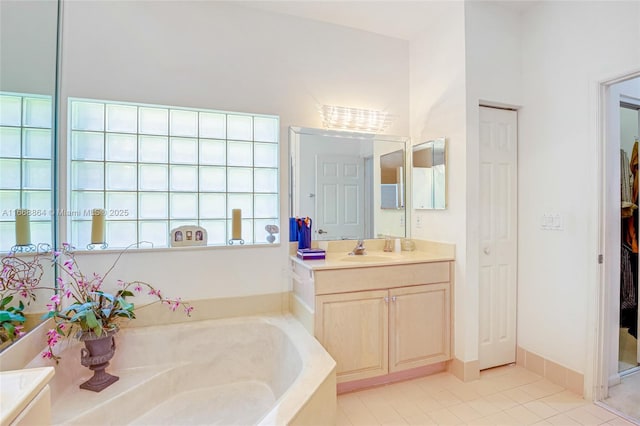 bathroom with tile patterned floors, vanity, and a tub