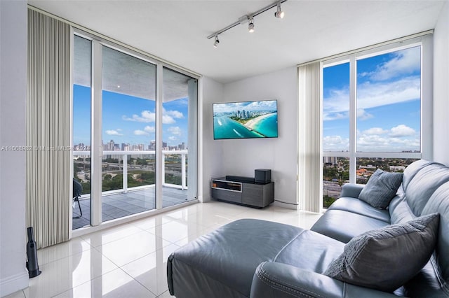 living room featuring rail lighting, a wall of windows, light tile patterned floors, and a wealth of natural light