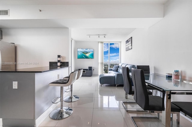 dining area featuring track lighting and light tile patterned flooring