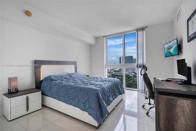 tiled bedroom featuring a wall of windows