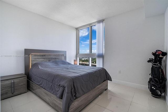 bedroom with a textured ceiling and light tile patterned floors