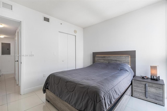 bedroom featuring electric panel and light tile patterned floors