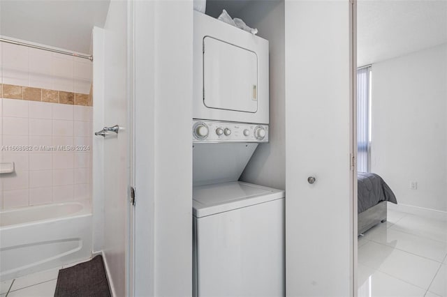 laundry room with stacked washer / drying machine and light tile patterned floors