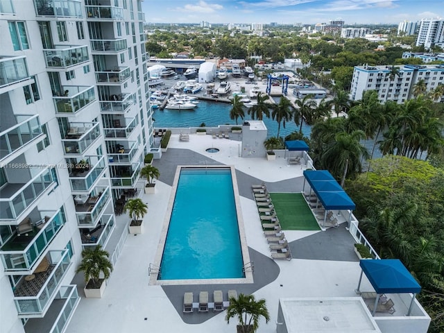 view of pool with a water view and a patio