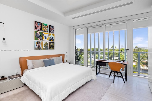 bedroom with multiple windows, access to outside, and light hardwood / wood-style floors