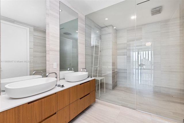 bathroom featuring vanity, tile walls, a tile shower, and tile patterned floors