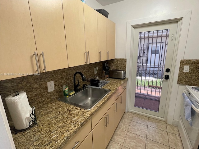 kitchen with light brown cabinets, sink, backsplash, dark stone counters, and white range with electric stovetop