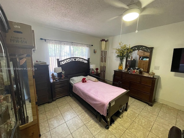 bedroom with a textured ceiling, light tile patterned floors, and ceiling fan