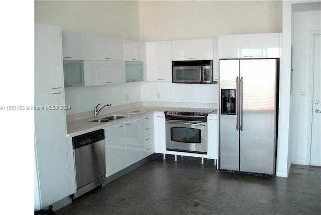 kitchen with stainless steel appliances, white cabinets, and sink