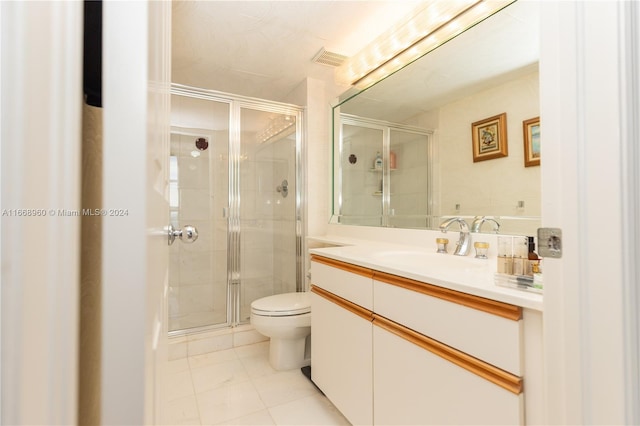 bathroom featuring vanity, a shower with shower door, toilet, and tile patterned floors