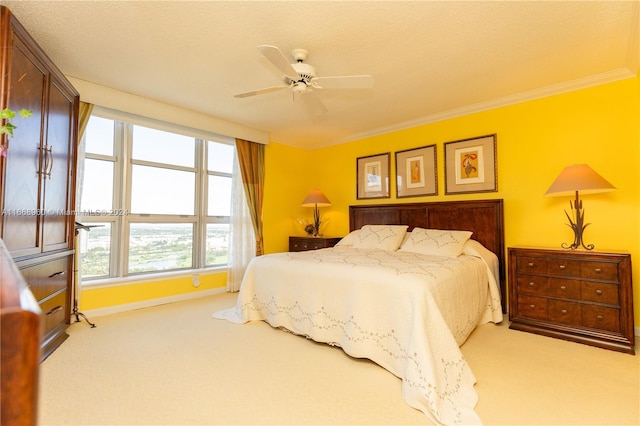 bedroom with ceiling fan, light colored carpet, a textured ceiling, and ornamental molding