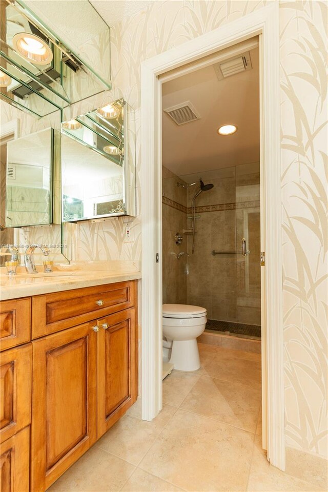 bathroom with tasteful backsplash, walk in shower, tile patterned floors, vanity, and toilet