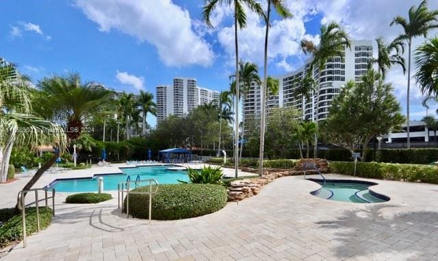 view of swimming pool featuring a patio area and a hot tub