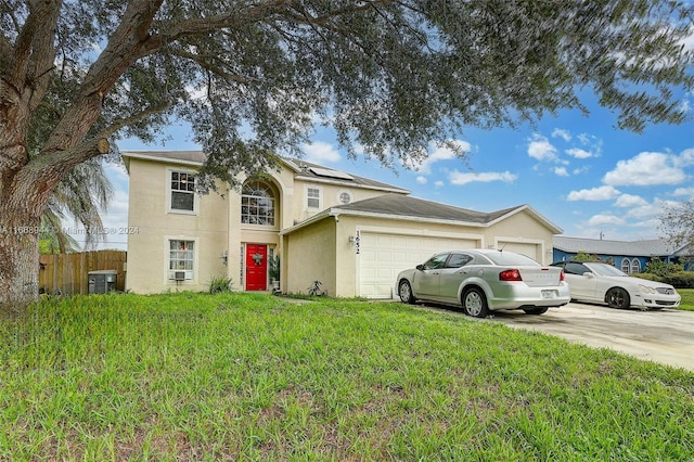 view of property featuring central AC unit, a front yard, and a garage