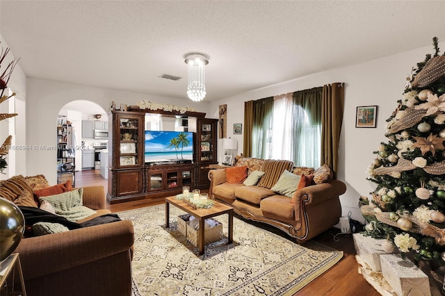 living room featuring light wood-type flooring and a textured ceiling