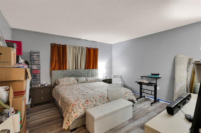 bedroom with light hardwood / wood-style floors and a textured ceiling