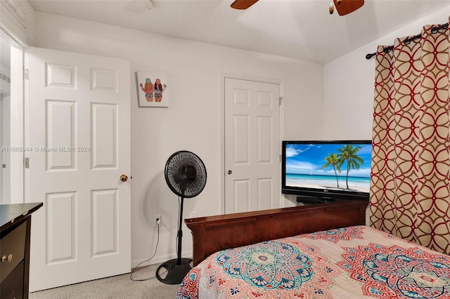 bedroom featuring ceiling fan, light colored carpet, and a textured ceiling