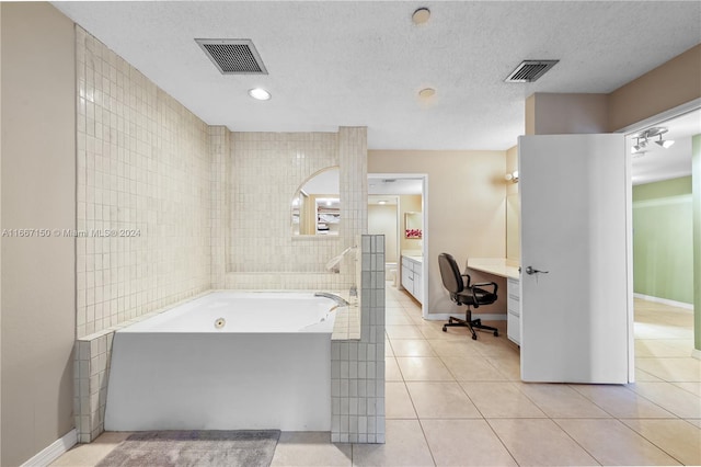 bathroom with a bathtub, tile patterned floors, tile walls, and vanity