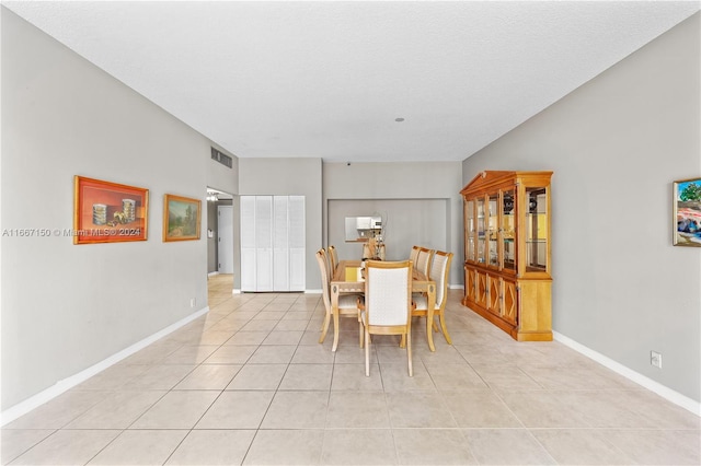 tiled dining area featuring a textured ceiling