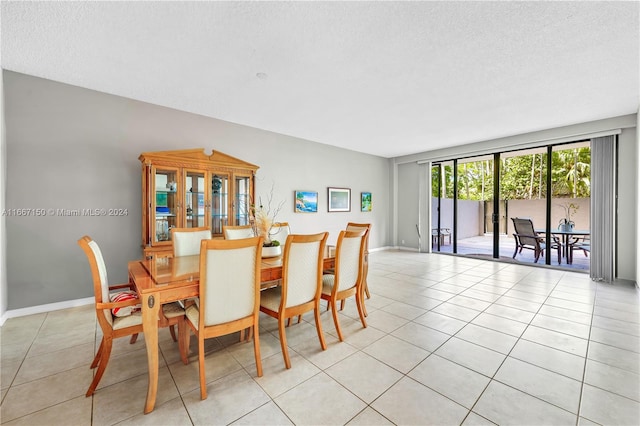 dining space with a textured ceiling and light tile patterned floors