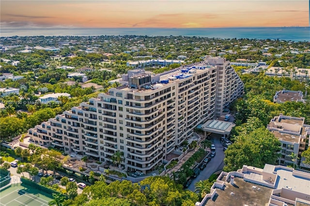 aerial view at dusk featuring a water view