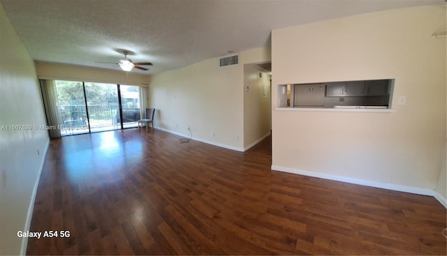 spare room with dark hardwood / wood-style floors, a textured ceiling, and ceiling fan