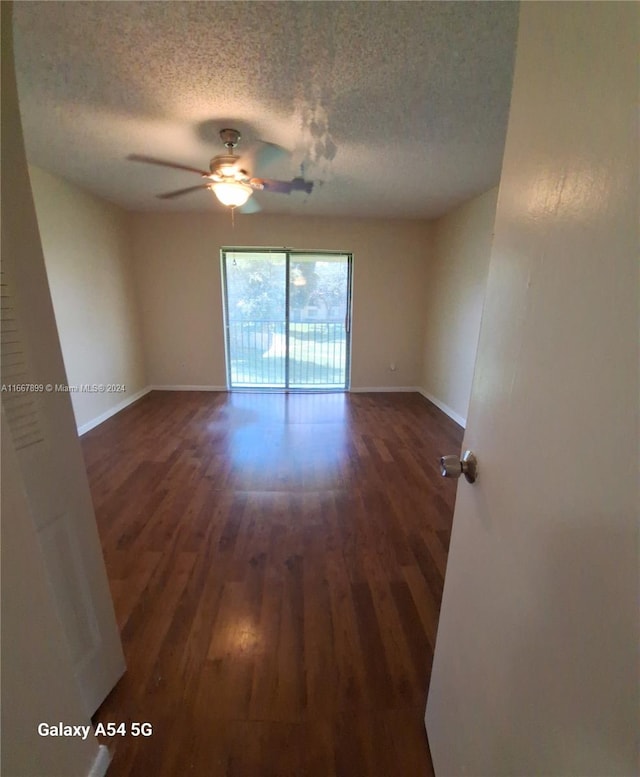 empty room featuring dark hardwood / wood-style flooring, a textured ceiling, and ceiling fan