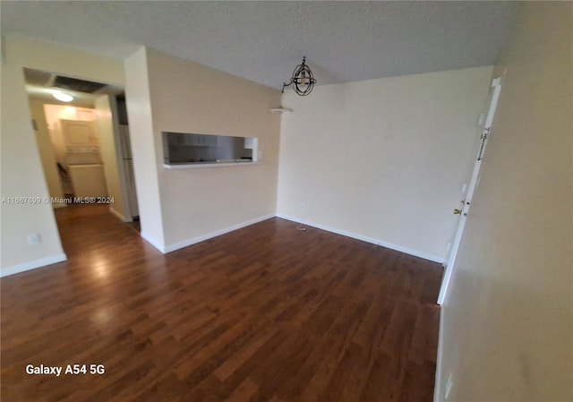 unfurnished living room with a textured ceiling and dark hardwood / wood-style flooring