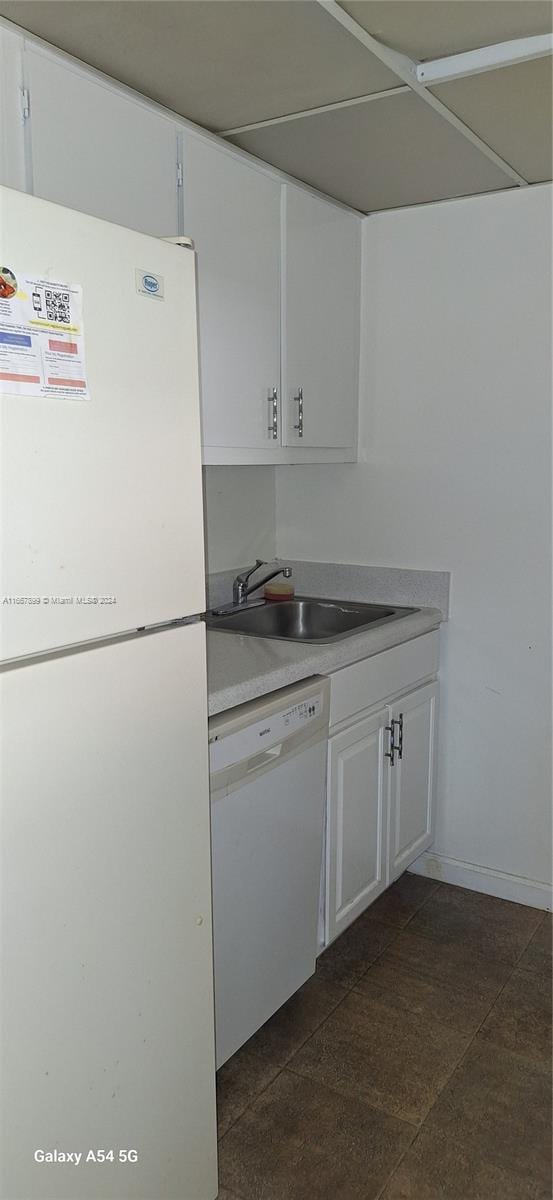 kitchen featuring white appliances, sink, and white cabinets