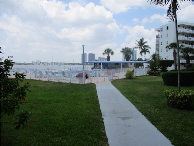 view of property's community featuring a lawn, a water view, and a pool