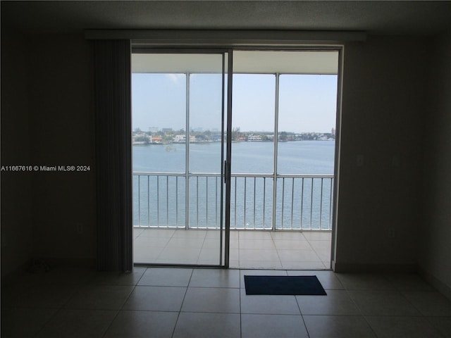 tiled empty room featuring a water view