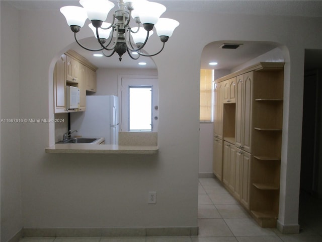 kitchen with a chandelier, sink, white appliances, light brown cabinets, and light tile patterned floors