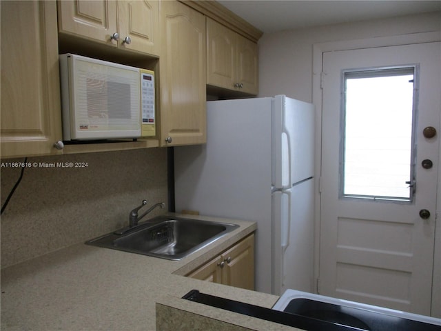 kitchen with backsplash, light brown cabinets, and sink