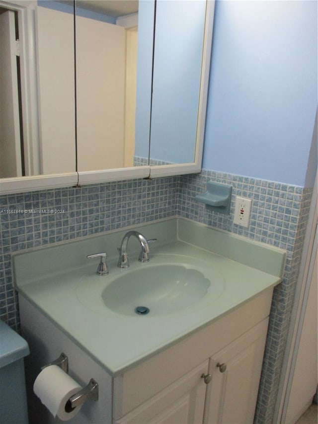 bathroom featuring vanity and tile walls